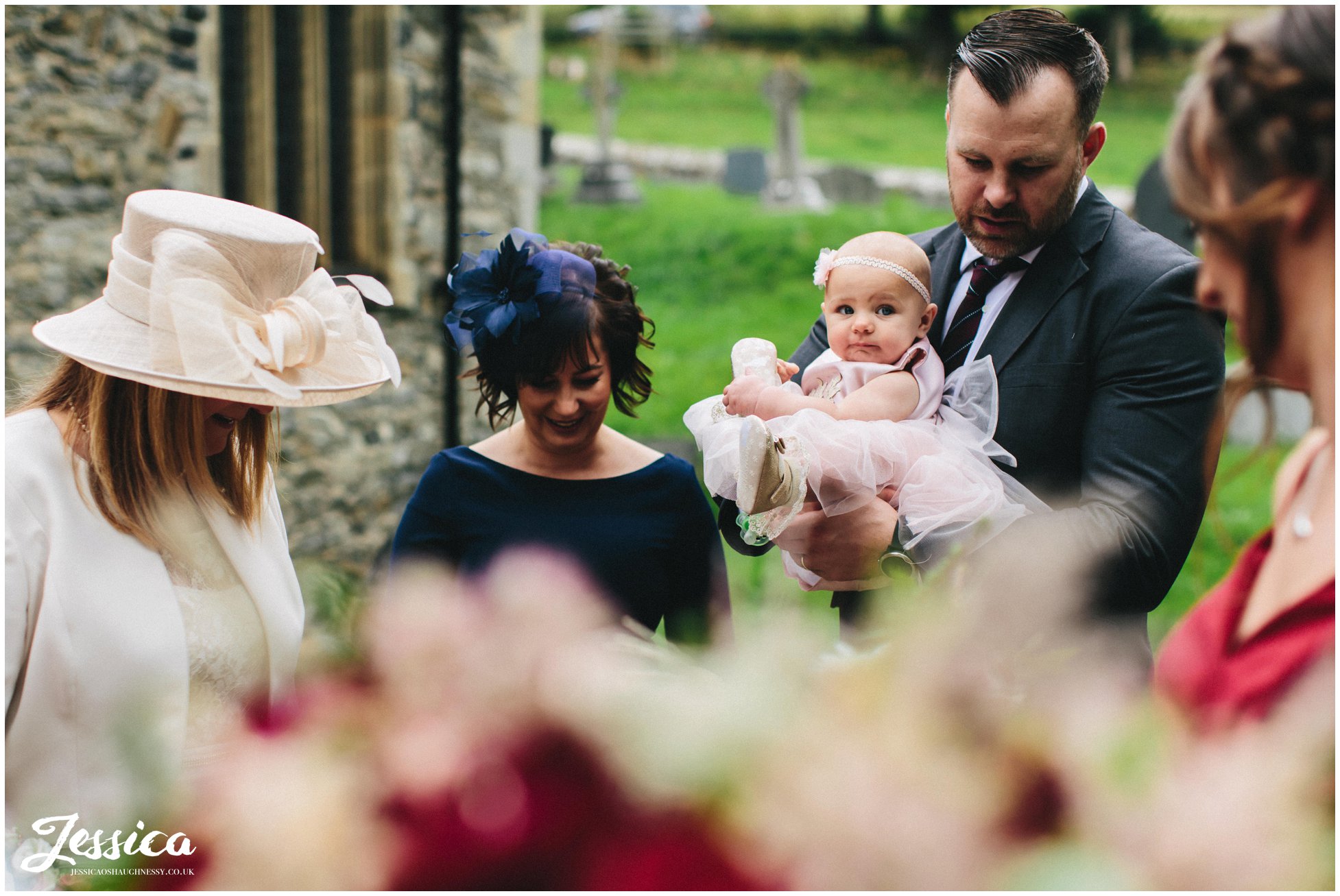 young flower girl being held by her father