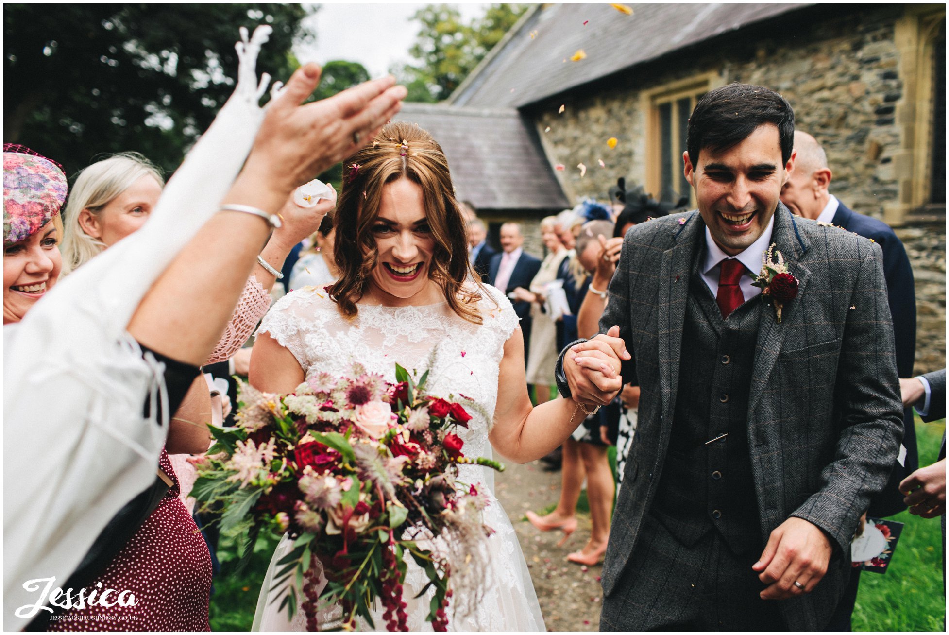 the couple are showered in confetti at Llantysilio church, north wales