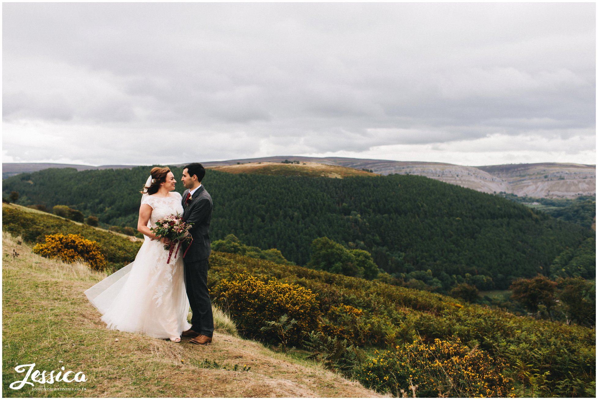 the newly wed's hold each other at the top of the welsh valleys