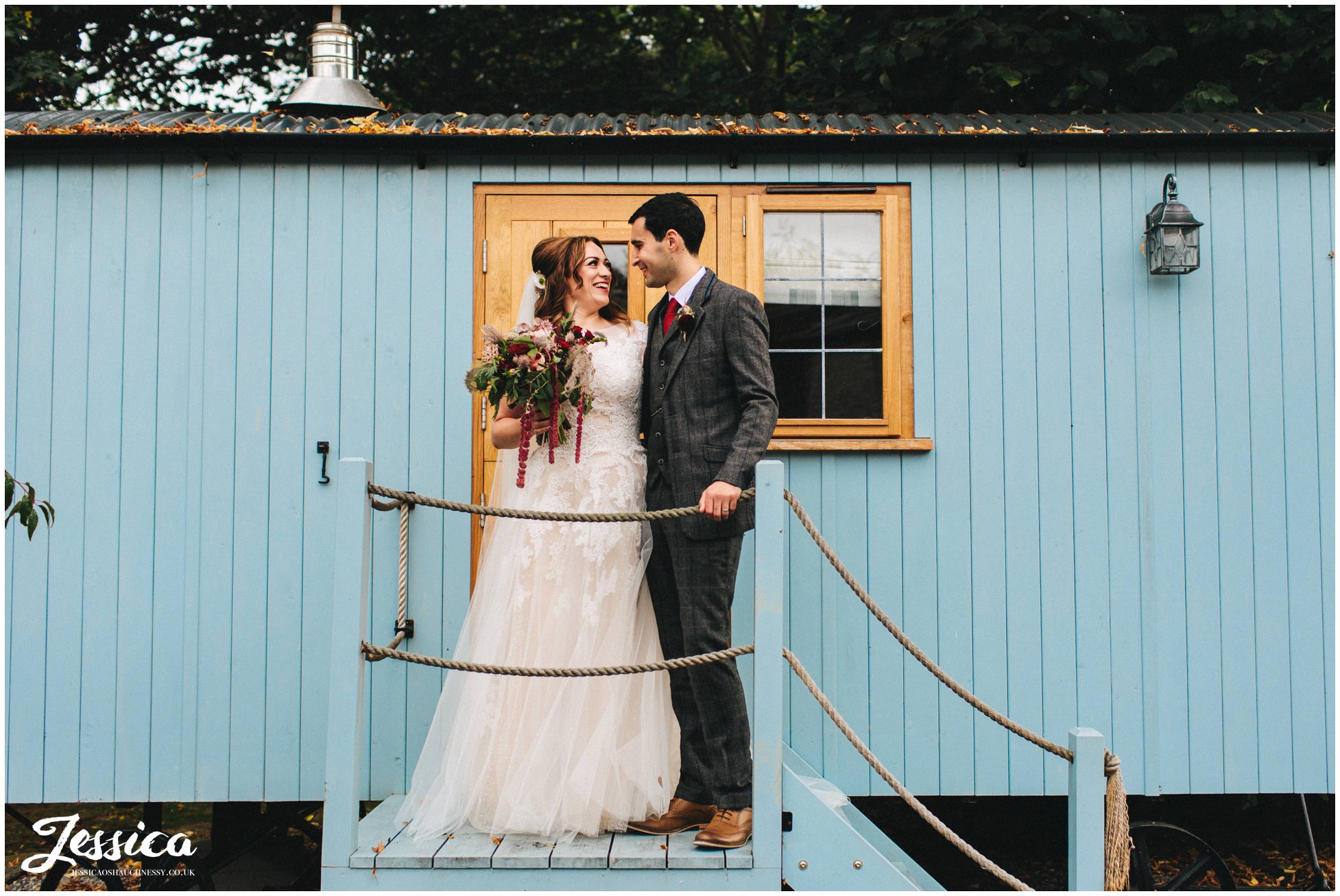 couple kiss on the steps up to the shepherds huts