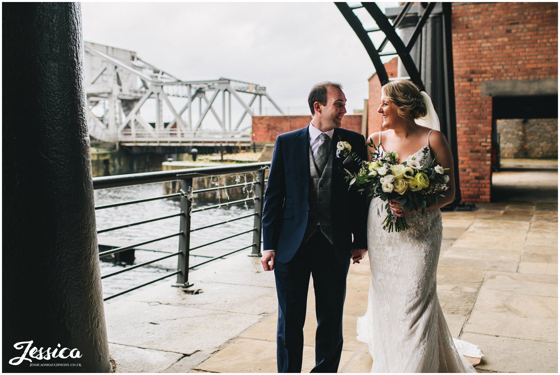 the couple walk hand in hand along liverpool docks