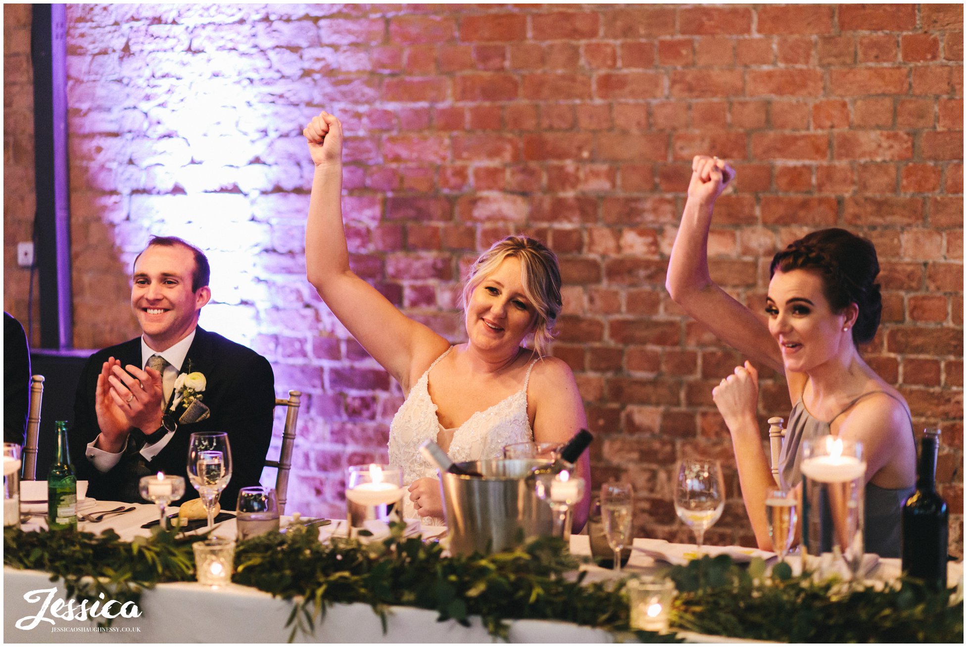 the bride &amp; maid of honour cheer during the wedding speeches