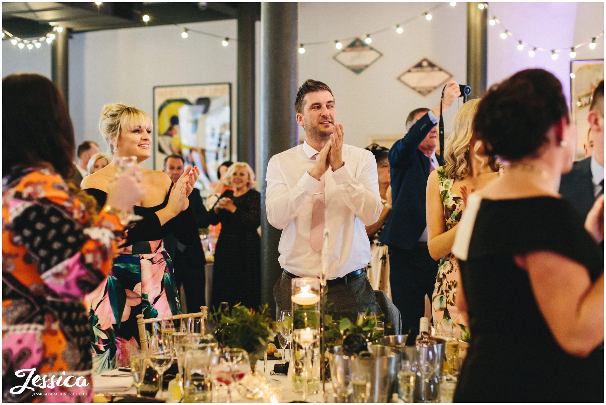 wedding guests clap as the couple enter