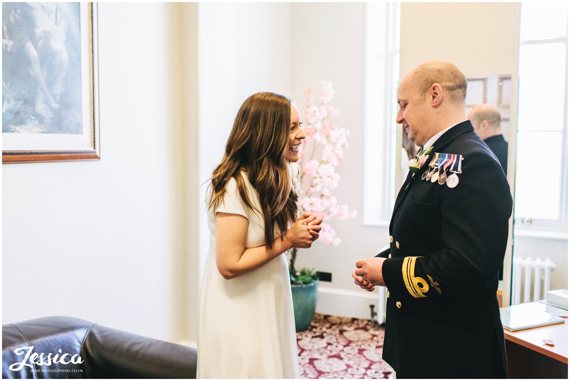 the bride laughs as the groom gets ready to put on her ring