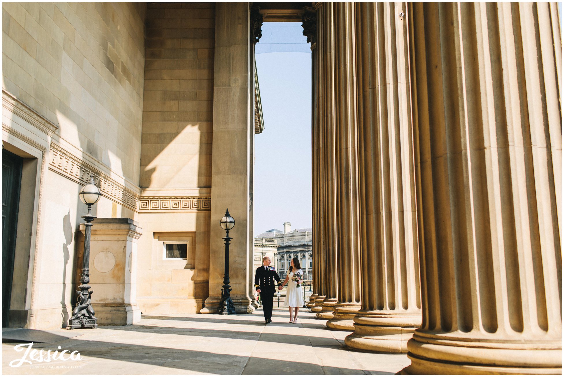 newly wed's walk between the columns after their elopement at st georges hall