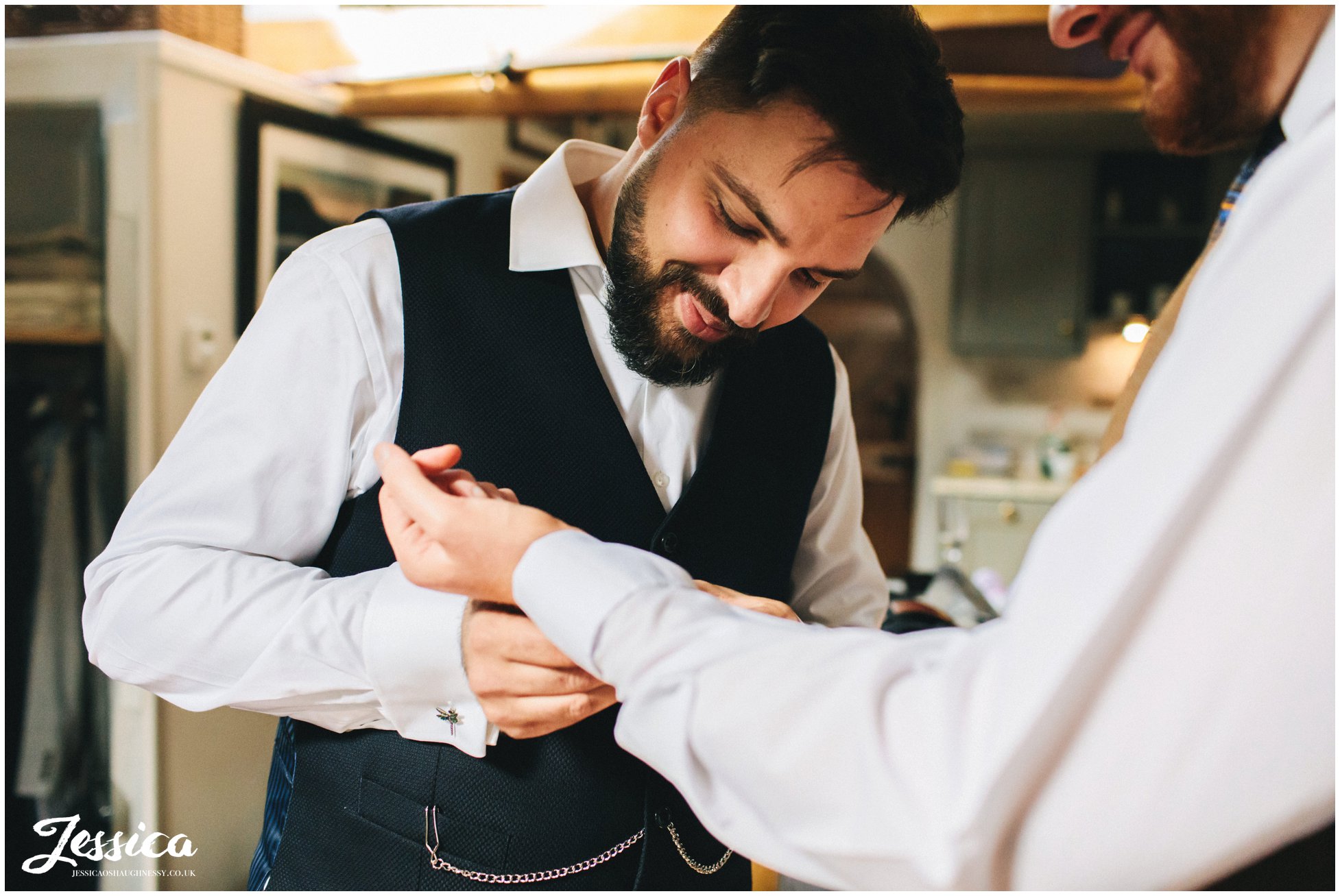Groom fastens his fiance's cufflinks