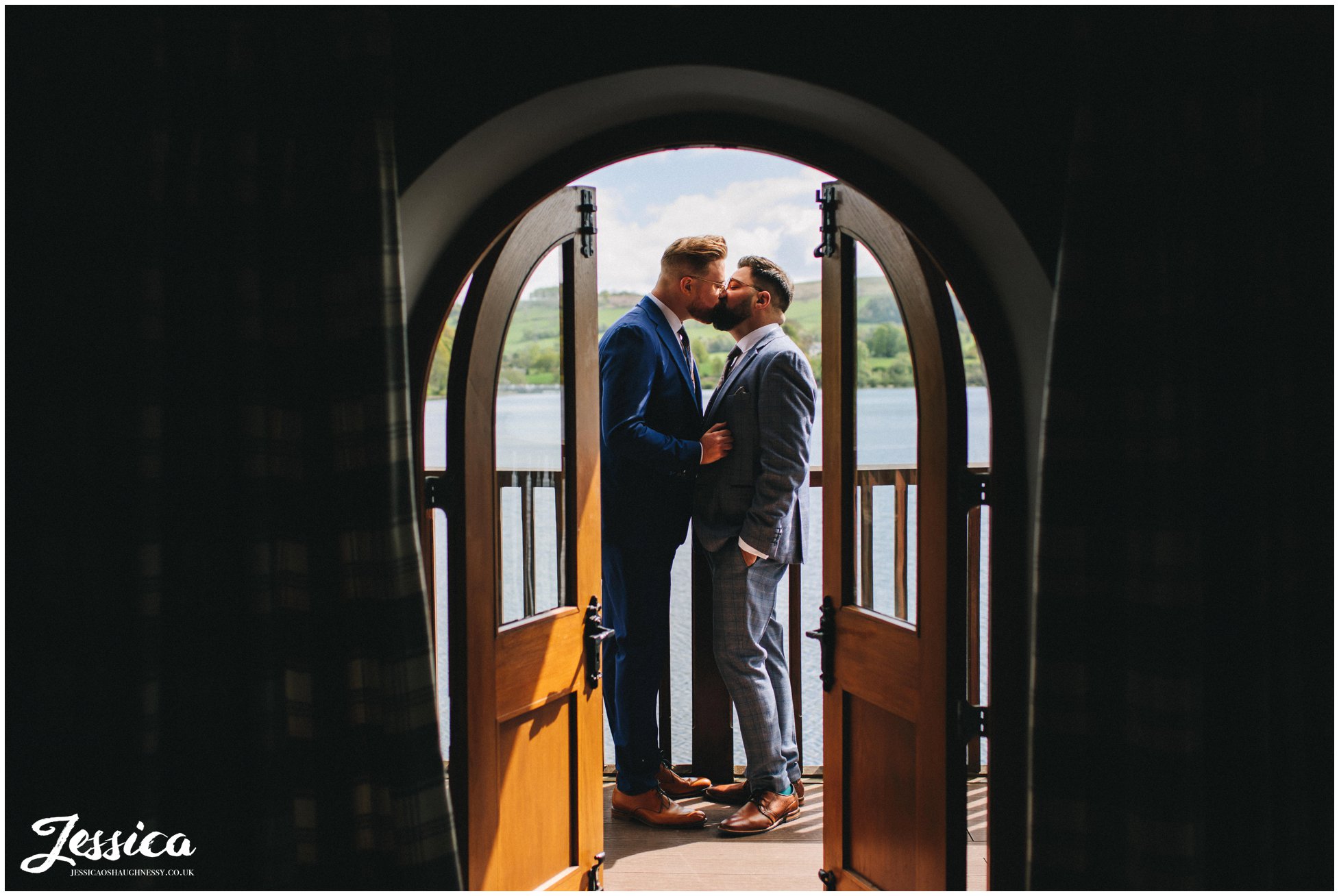 The grooms kiss on the balcony of the boathouse, ullswater