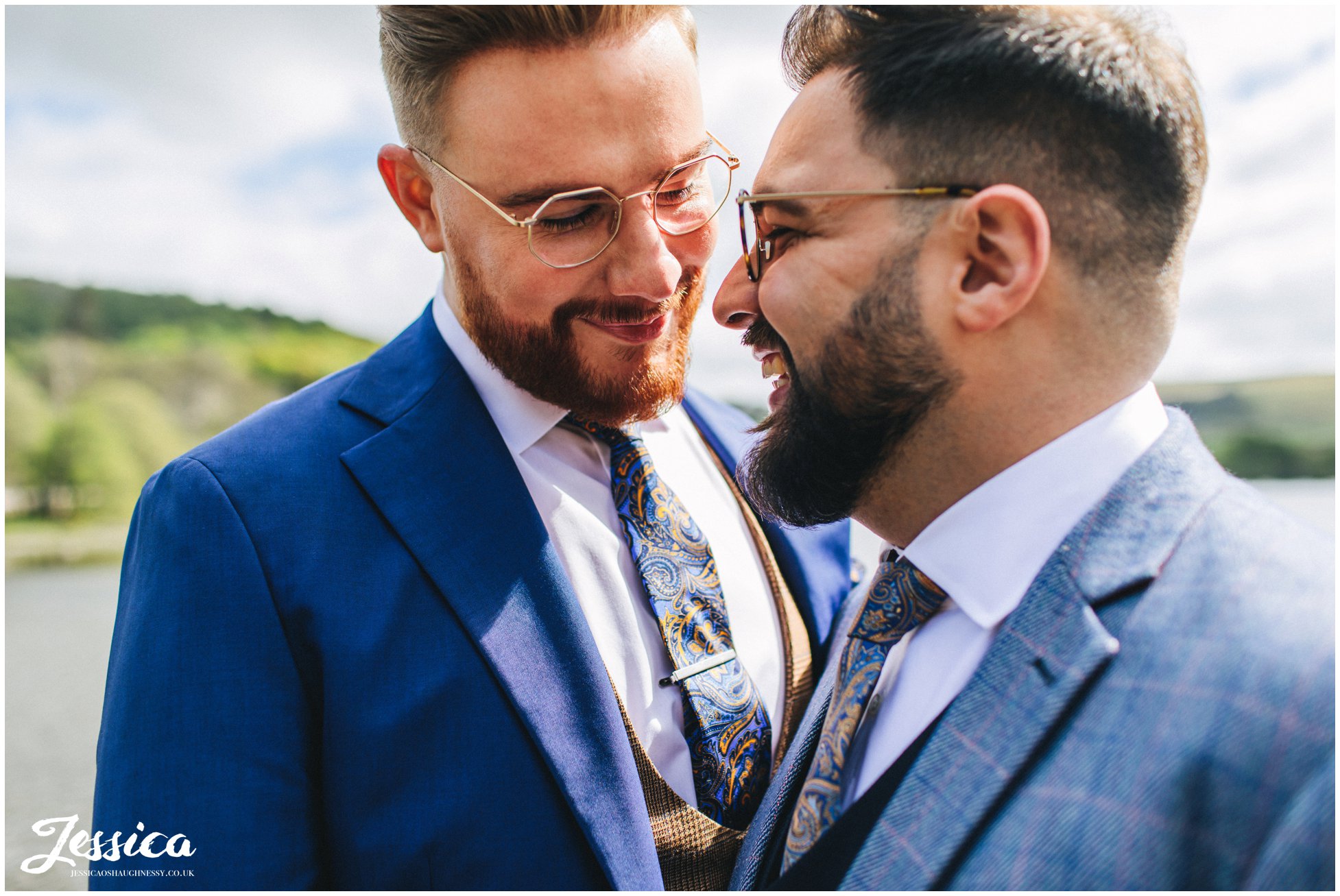 the grooms have photographs taken on the jetty at the boathouse
