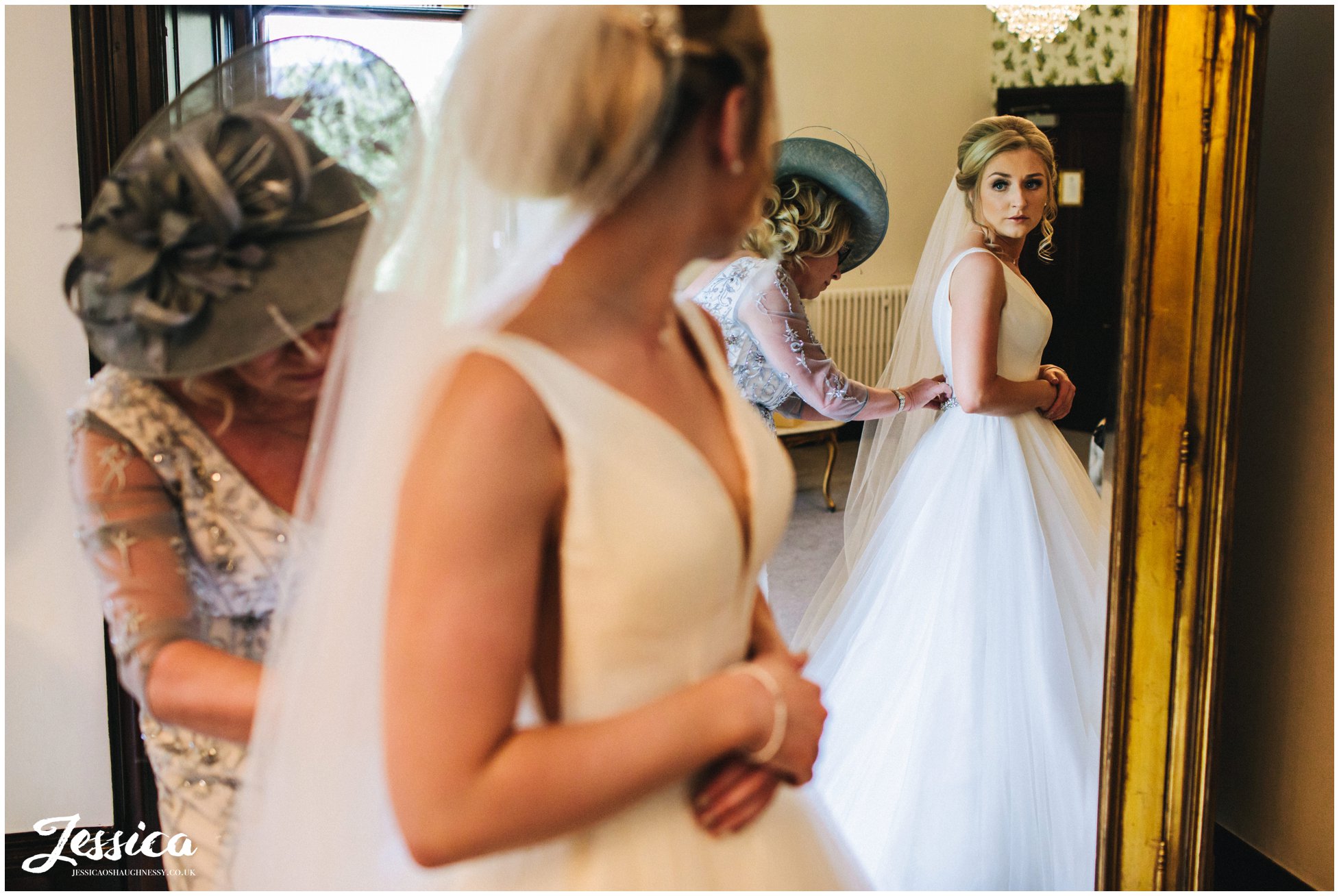 mother of the bride fastens wedding dress