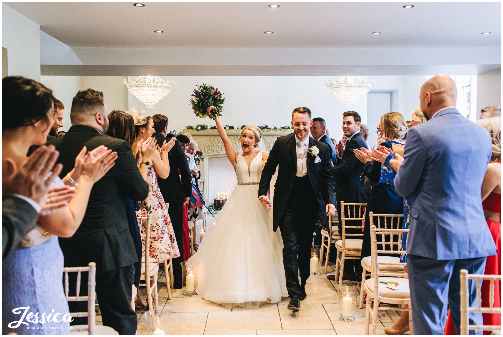 newly wed's cheer as they walk down the aisle