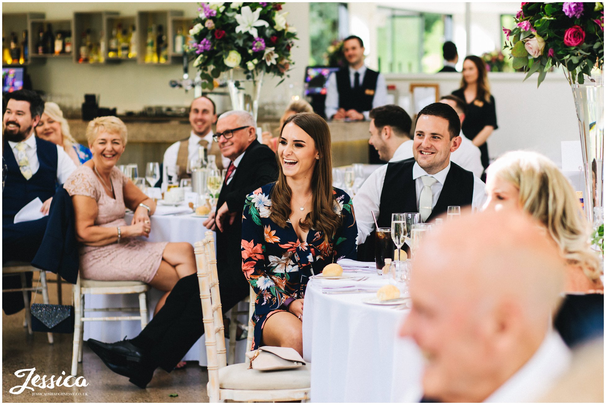 wedding guests laugh as the speeches continue