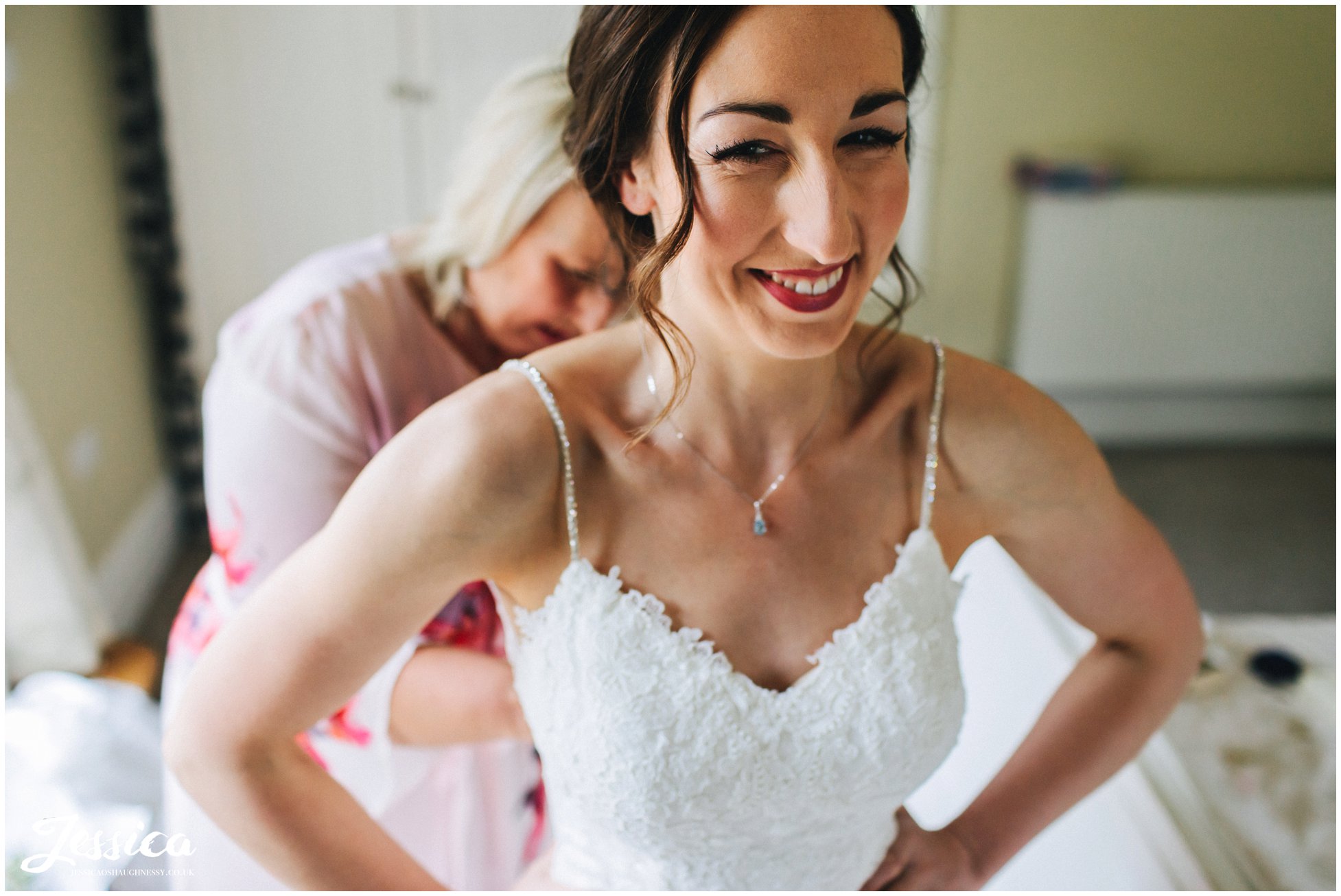 bride gets into her wedding dress with her from her mother