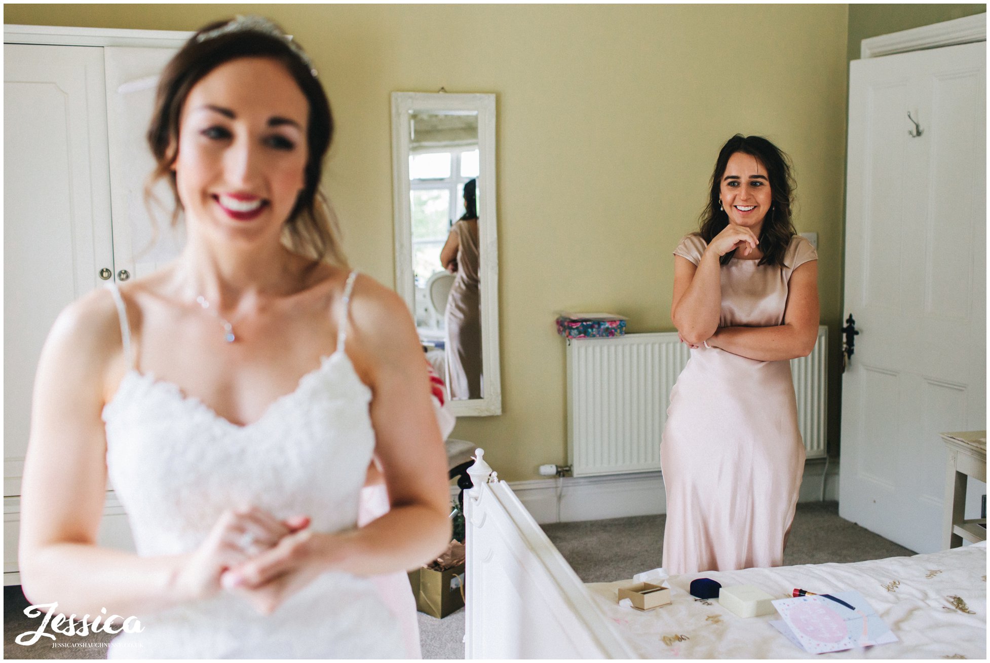 bridesmaid admires her sister in her wedding dress