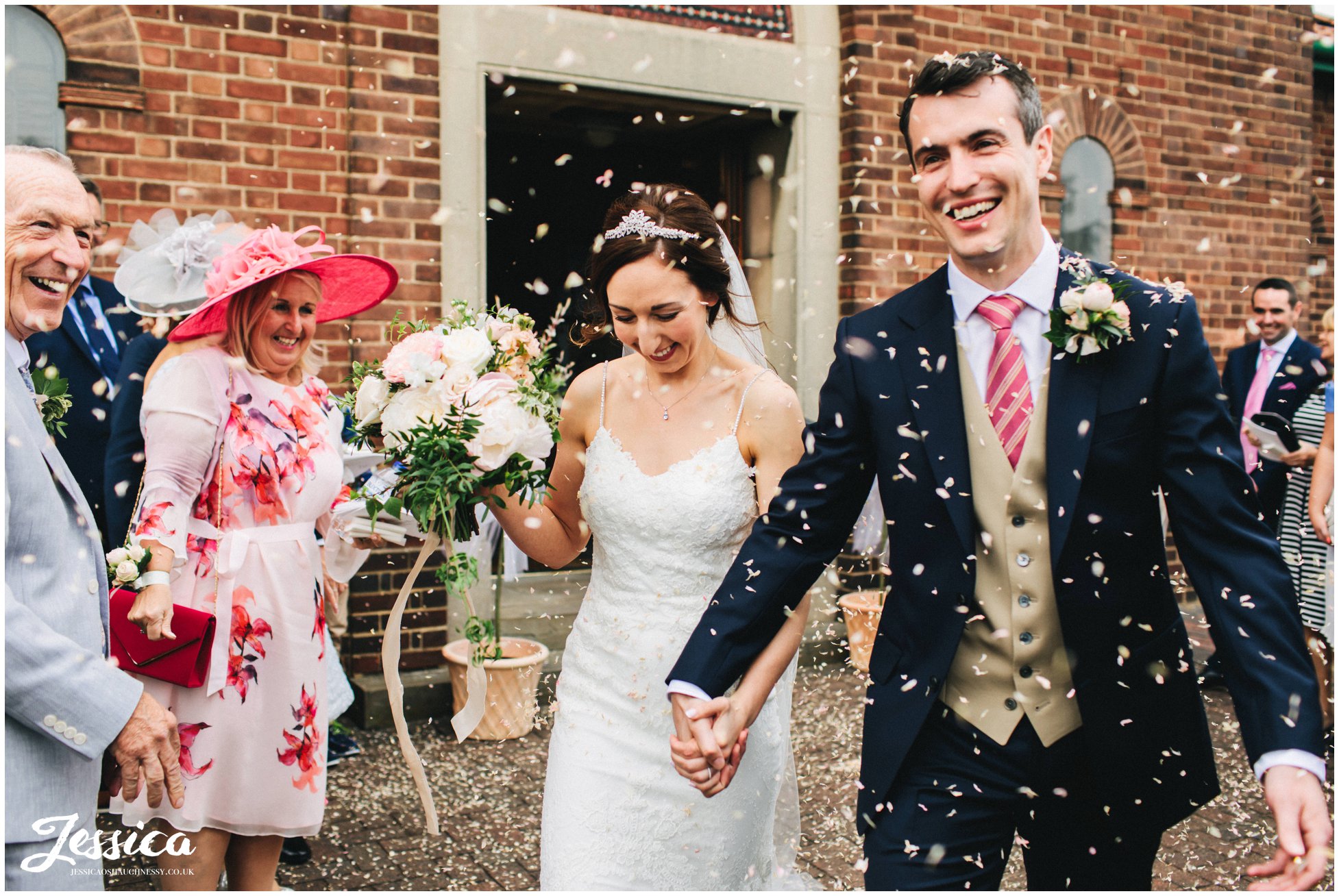 the bride and groom are showered in confetti at their wirral wedding