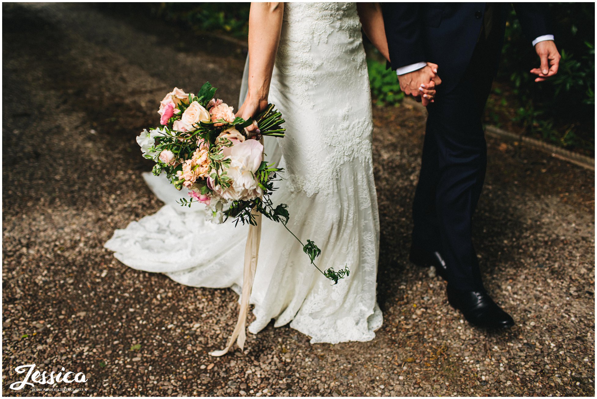 the couple walk hand in hand along mere brook house driveway