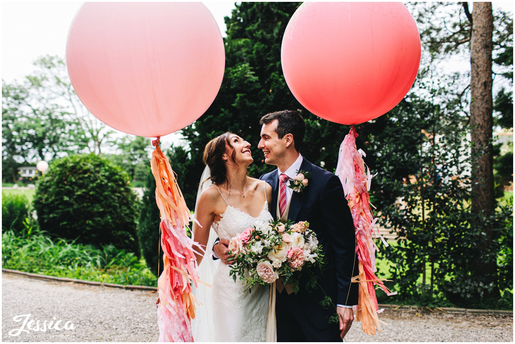 newly wed's pose with giant pink balloons