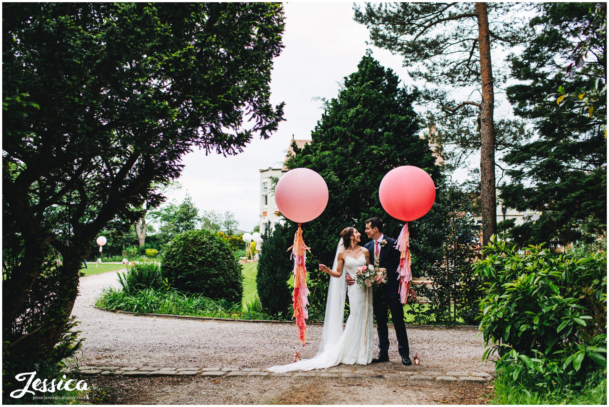couple stand with giant balloons at mere brook house