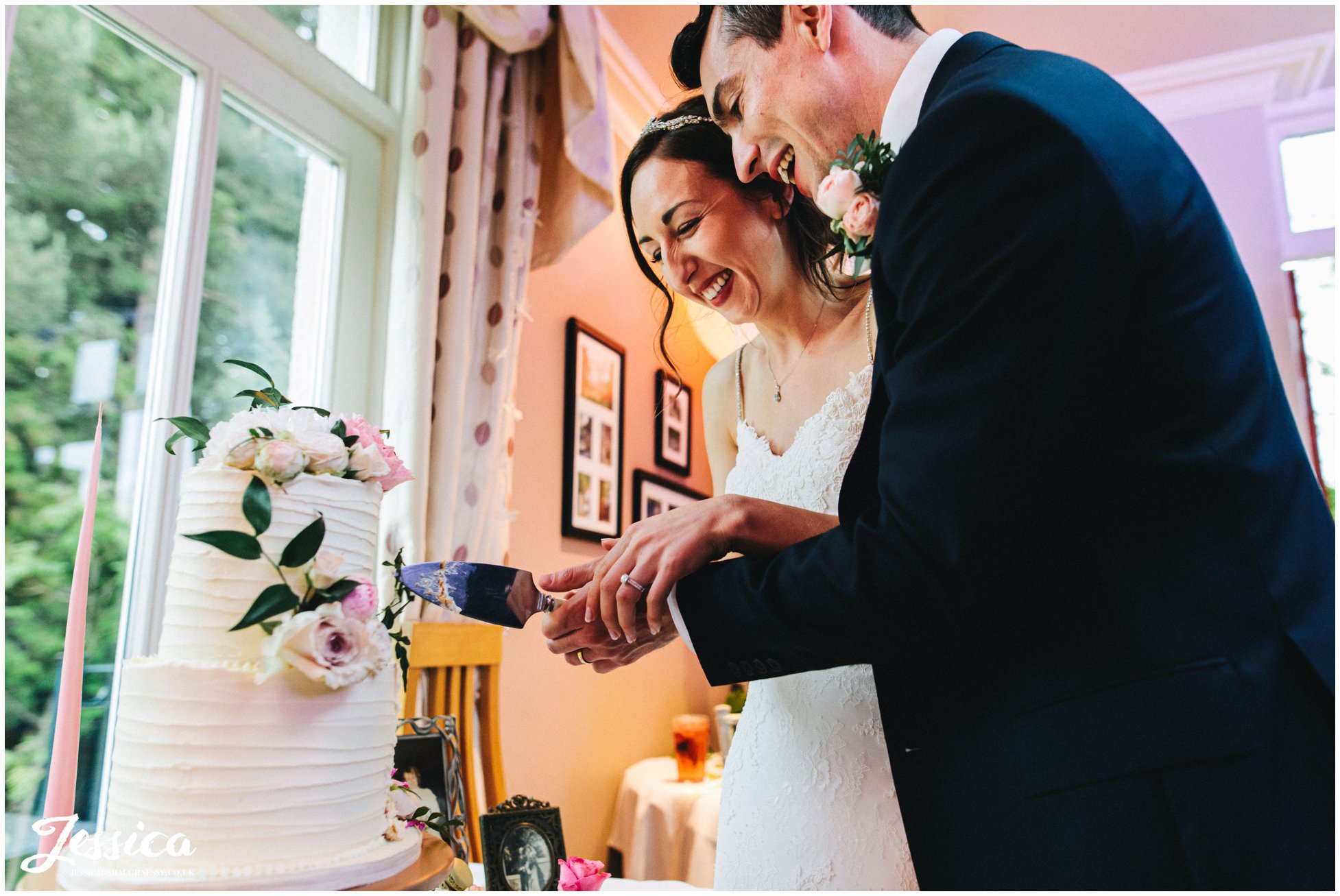 bride &amp; groom cut wedding cake together