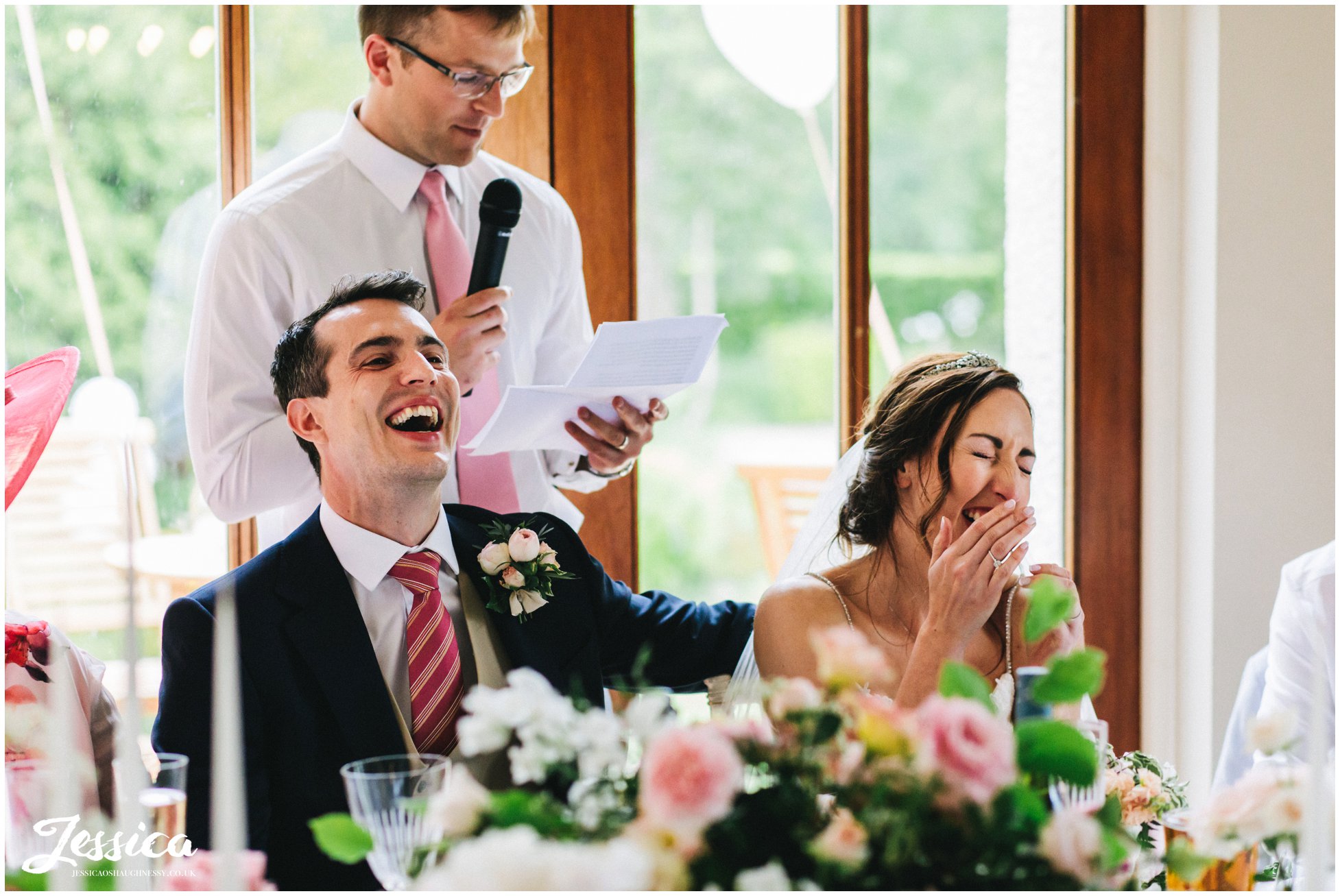 bride & groom laugh at the best man's speech