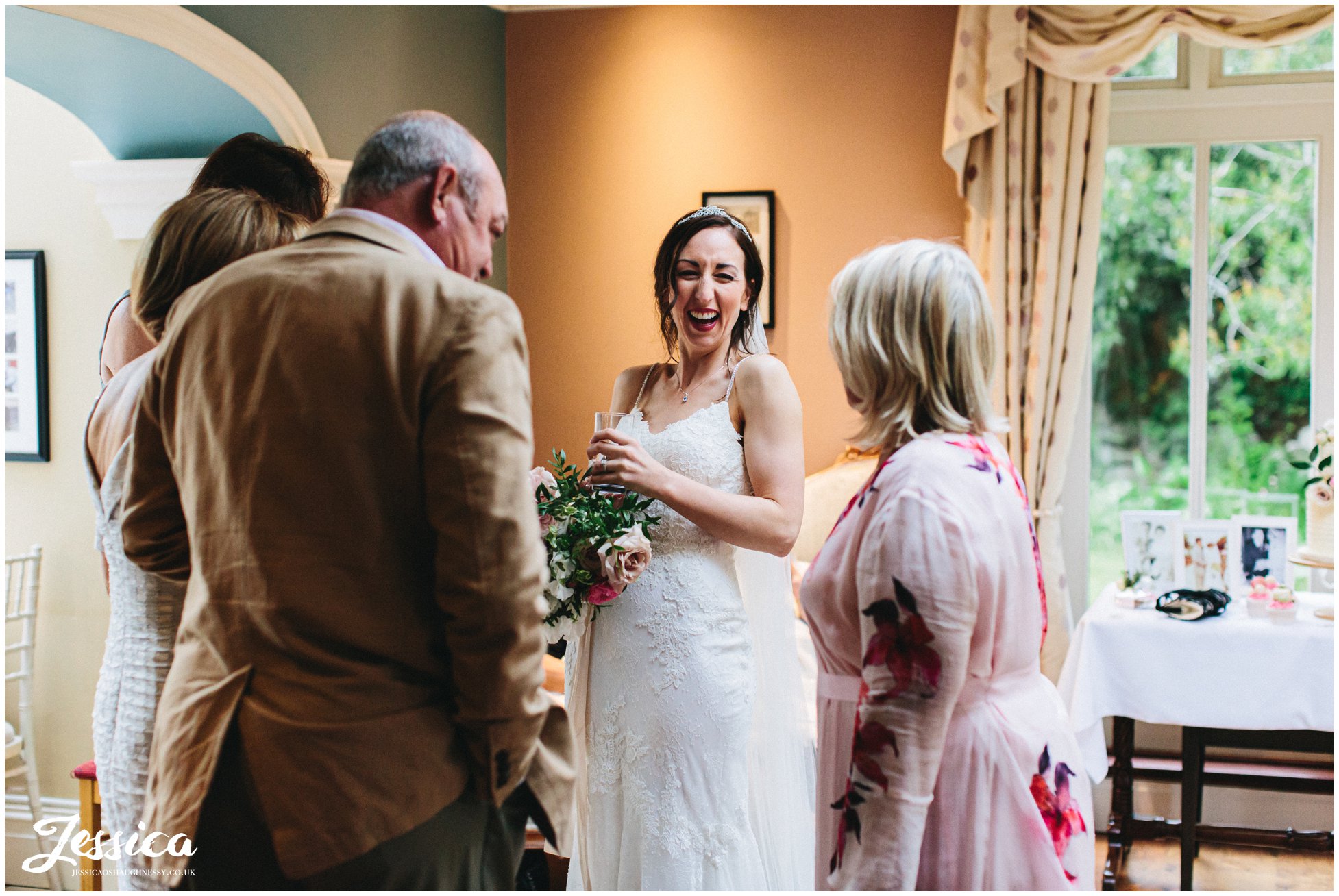 bride laughs with wedding guests at the evening reception