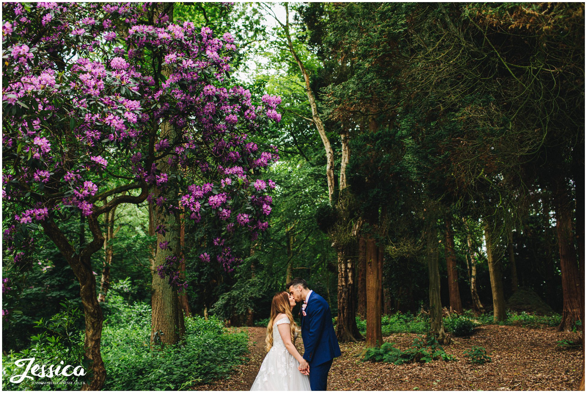 the couple kiss in the wooden area of the wedding venue