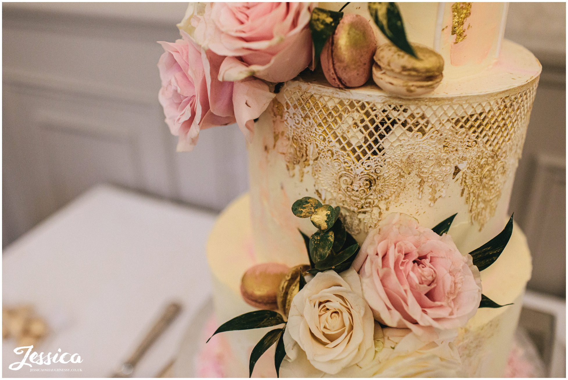 wedding cake decorated with macaroons &amp; flowers