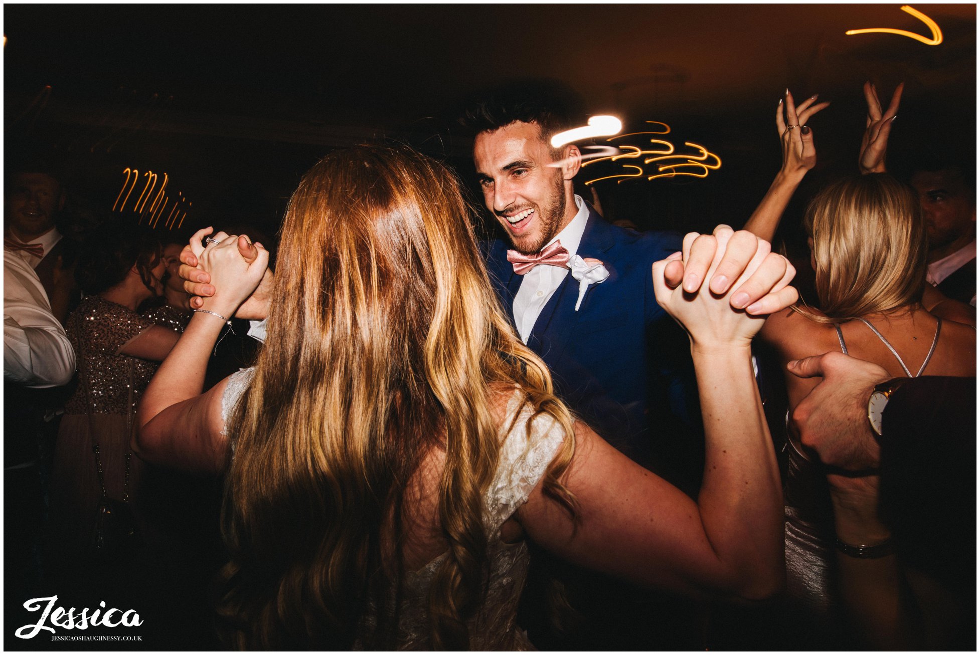 bride and groom dance as guests join them