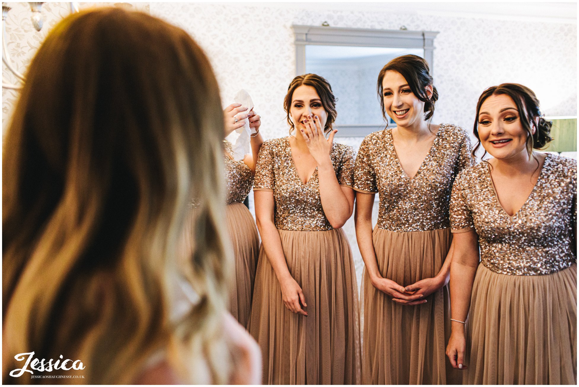 bridesmaids get emotional as they see the bride in her dress