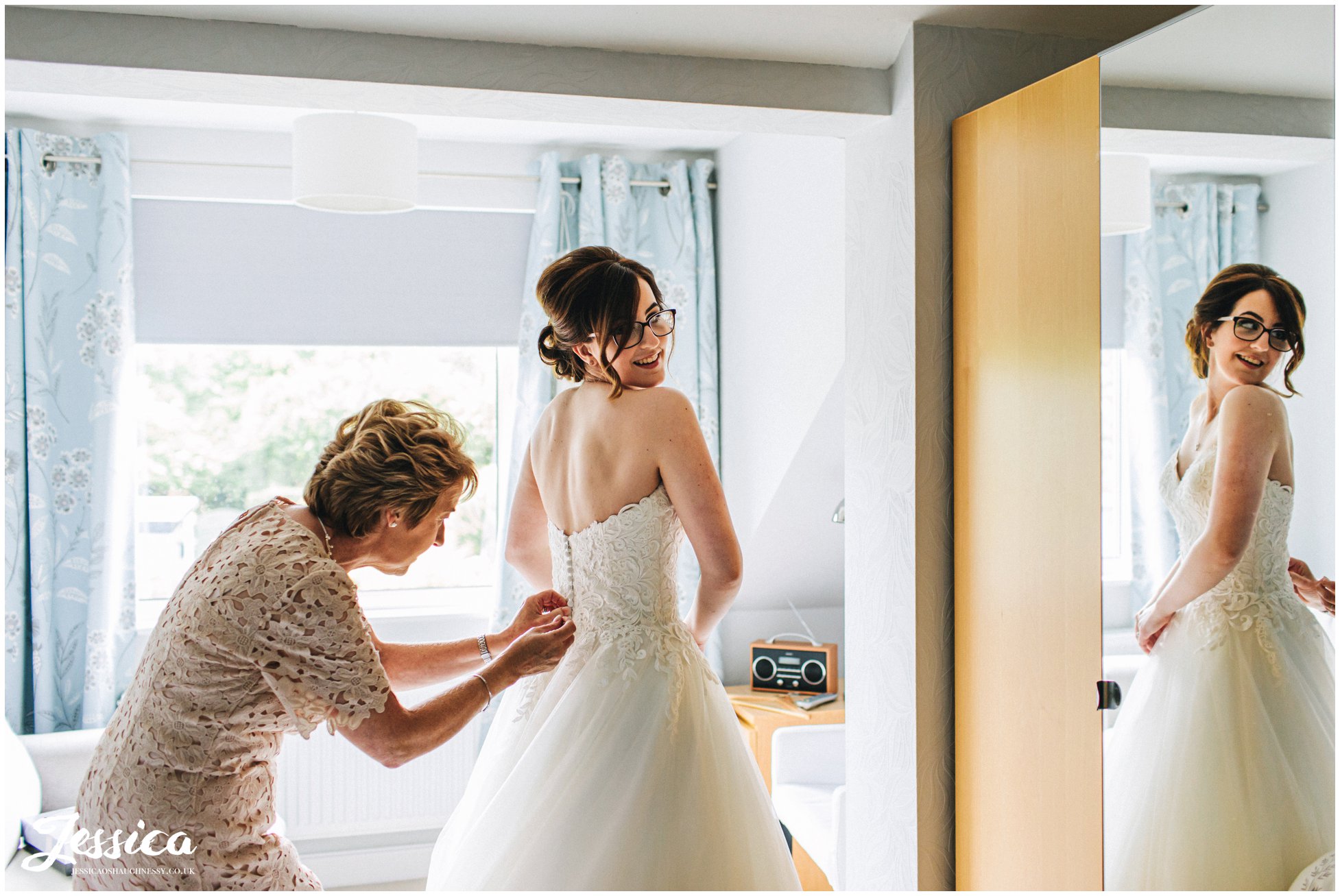 Mother of the bride fastens the wedding dress on her daughter