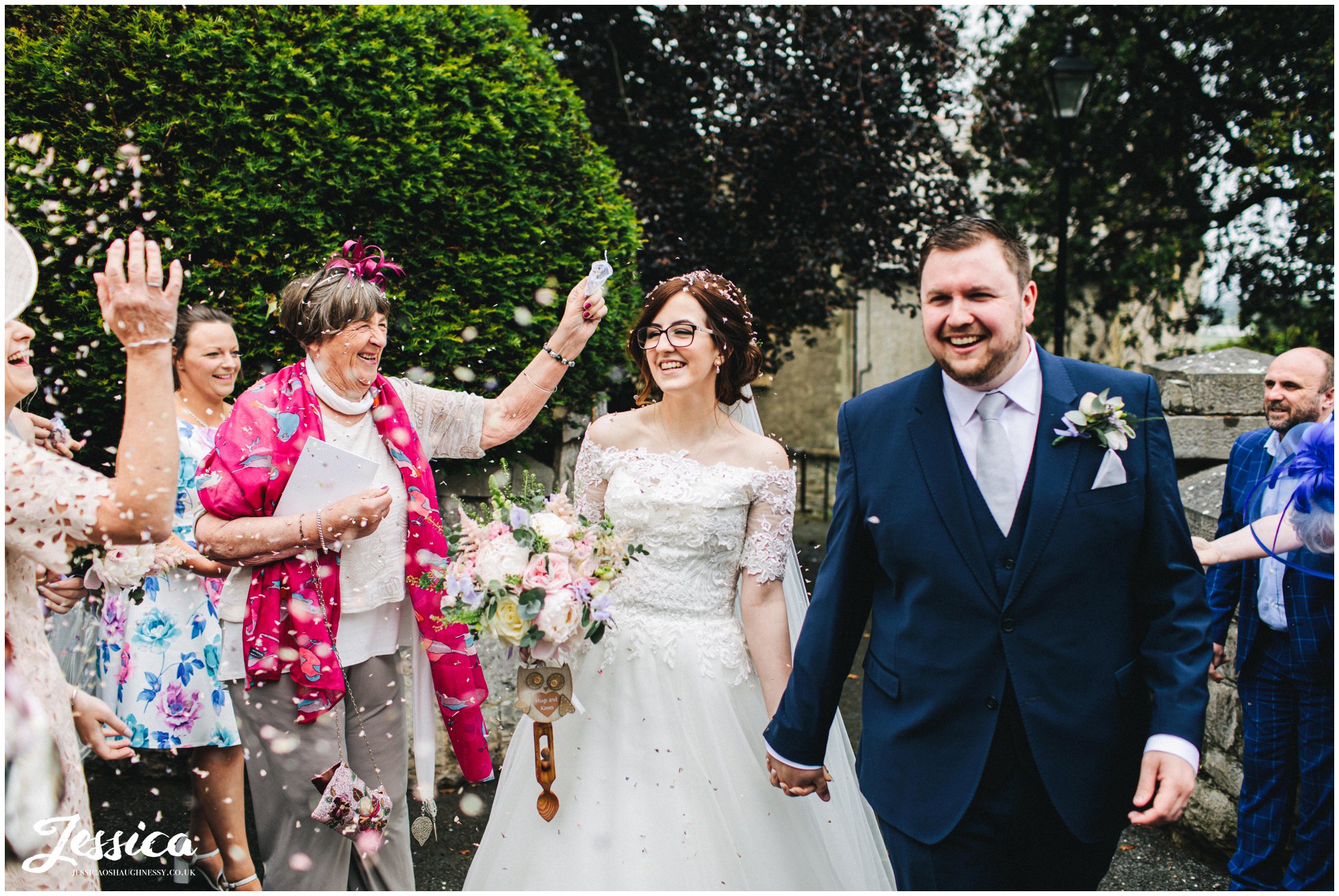 guests shower confetti over the new couple