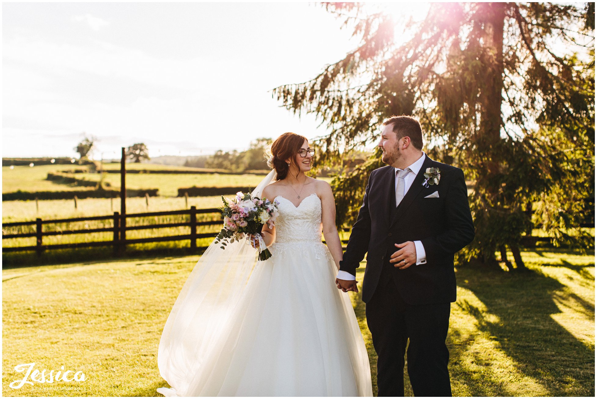 bride &amp; groom walk together in the venue grounds