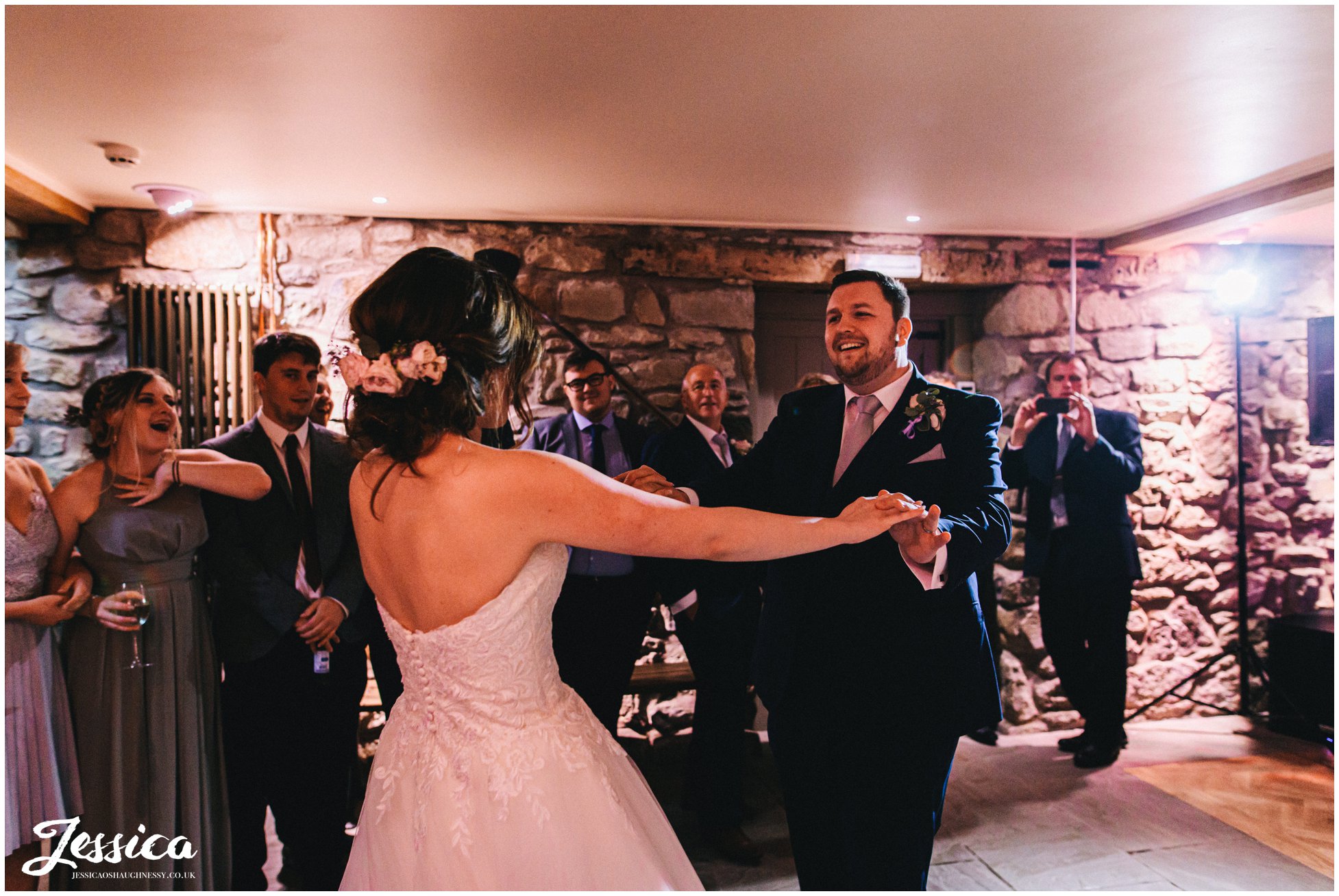 couple share their first dance in the old barn