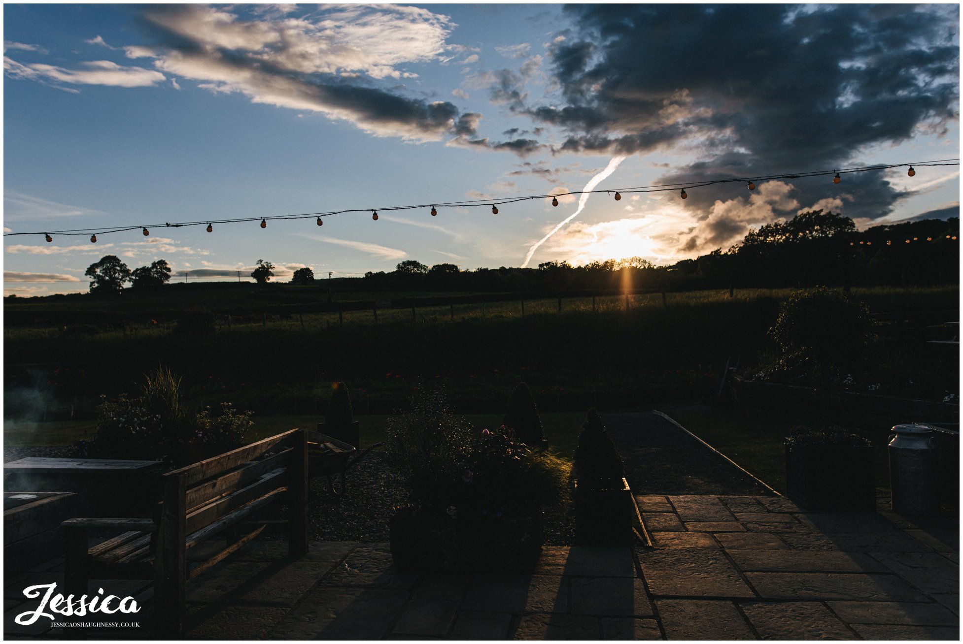 the sun goes down on the terrace at tower hill barns