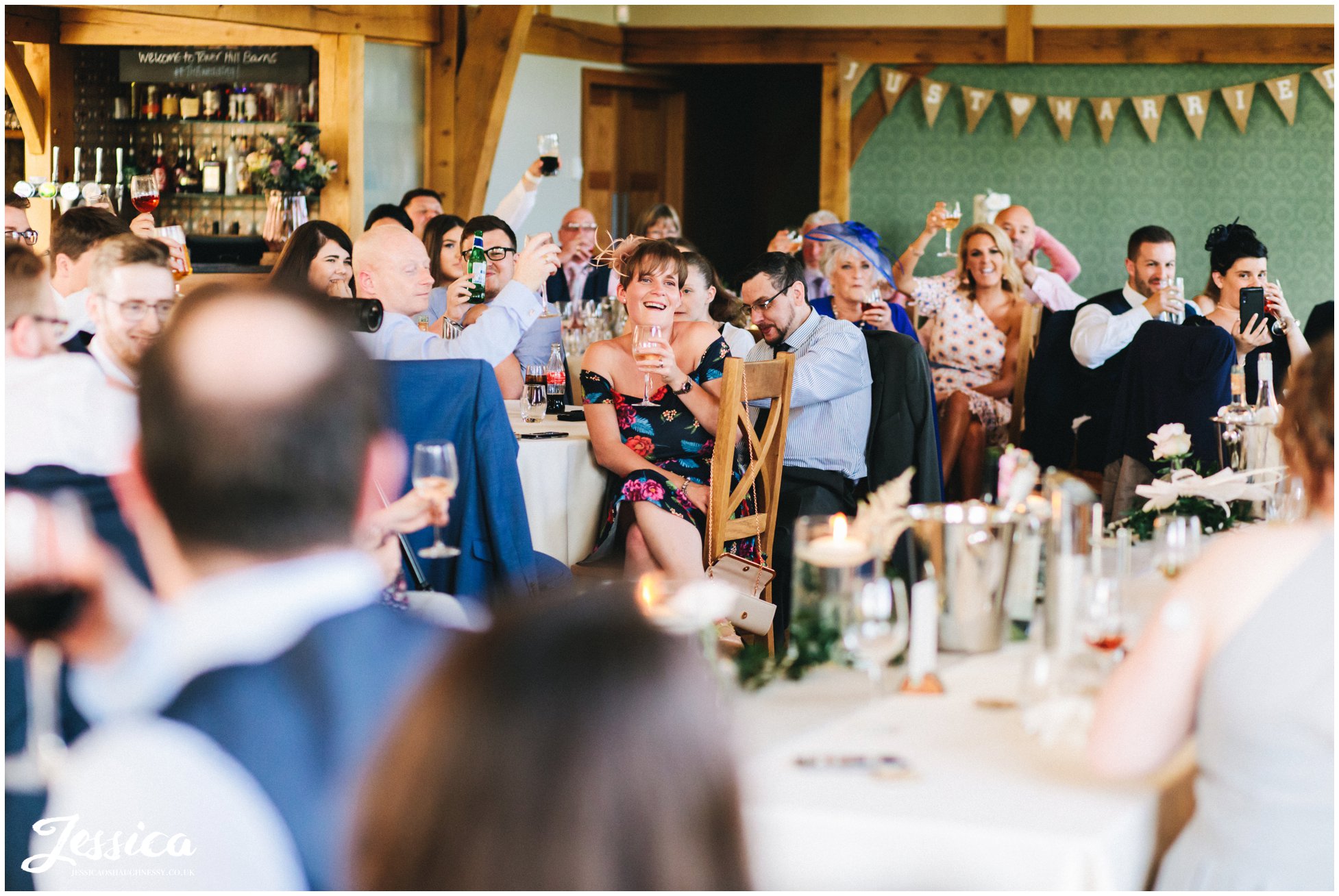 wedding guests laugh during the grooms speech