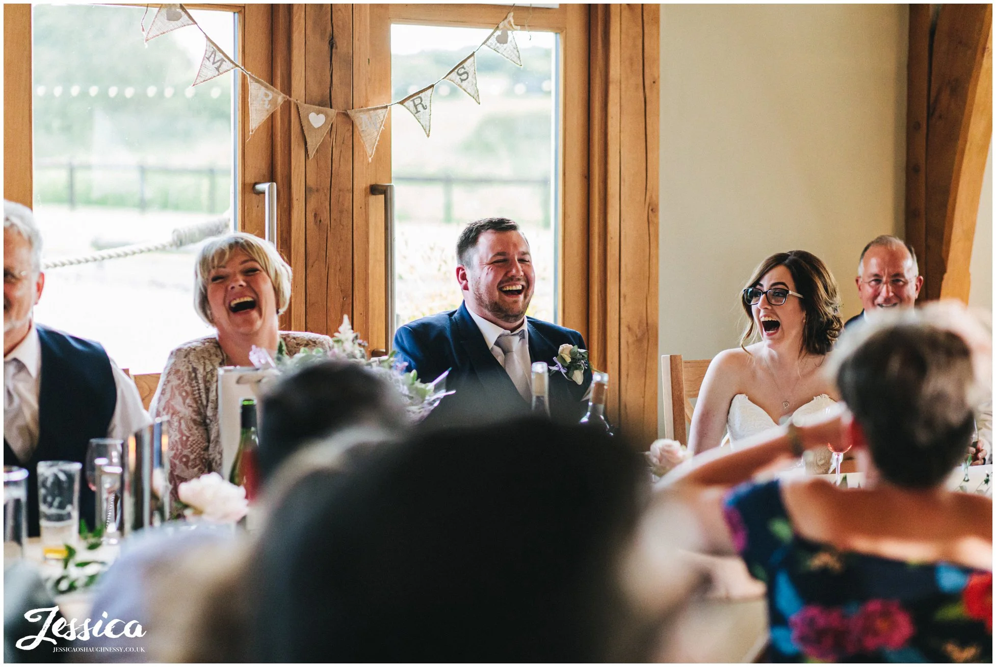 bride & groom laughing during the best mans speech