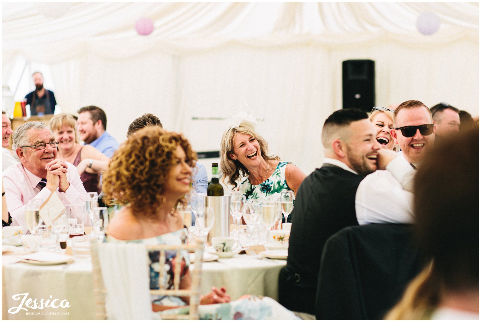 wedding guests laugh as the speeches are made at eyam hall in derbyshire