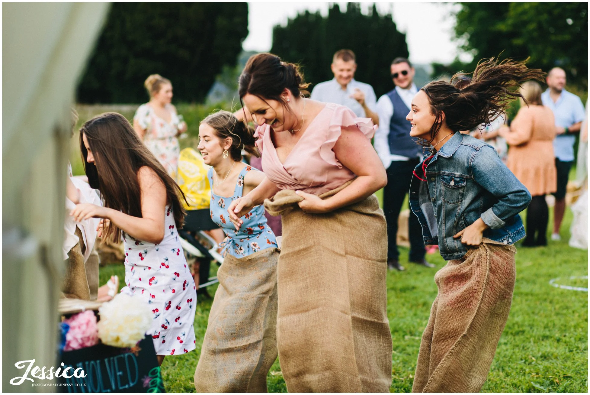 wedding guests enjoy a sack race in eyam hall gardens
