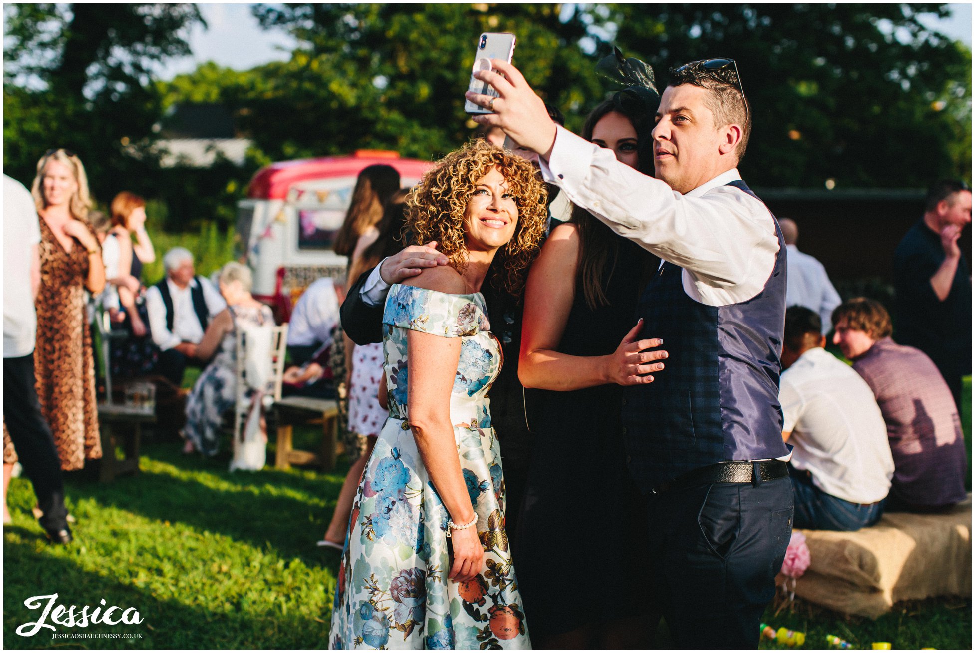 wedding guests take selfie in the evening sun