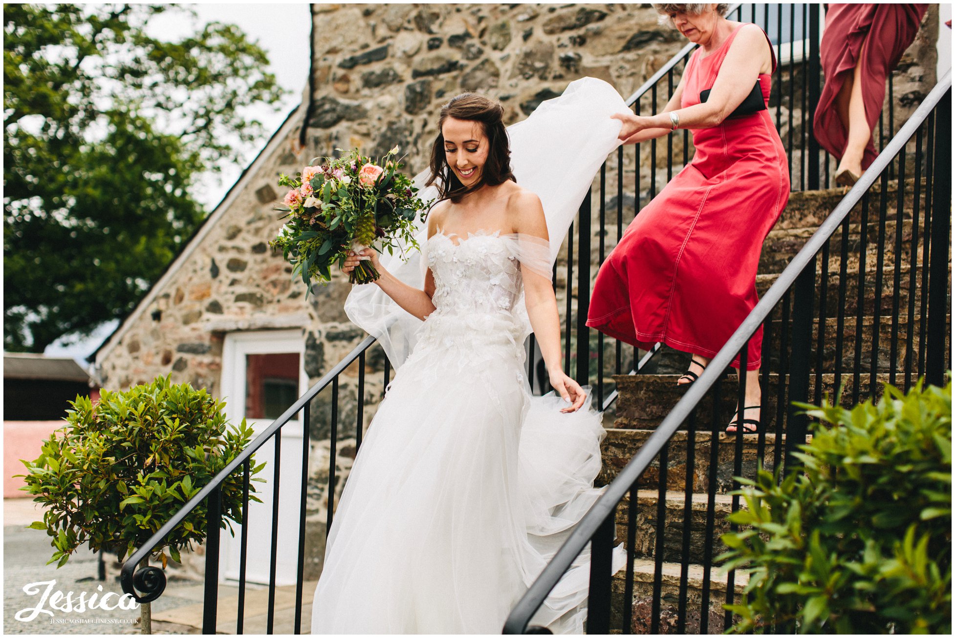 the bride walks down the barn stairs to the ceremony