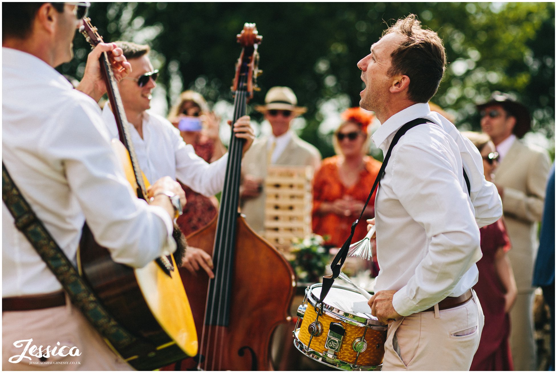 the band plays outside in the sun at the north wales wedding