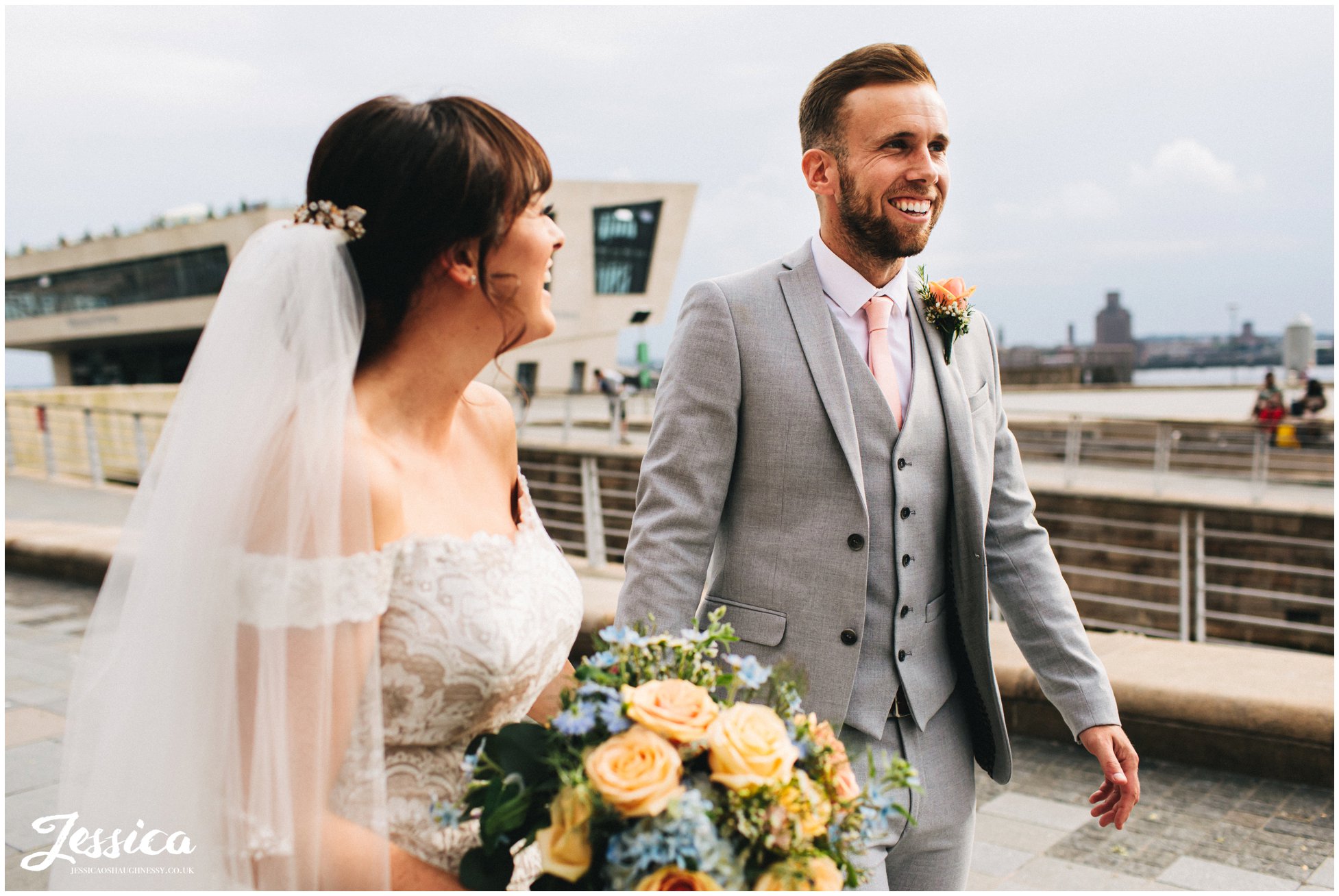 bride laughs at groom as they walk together