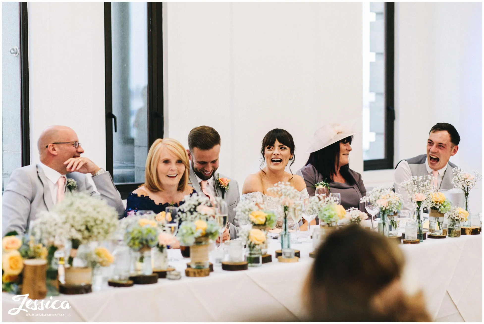 top table laugh during the best mans speech at the liver building