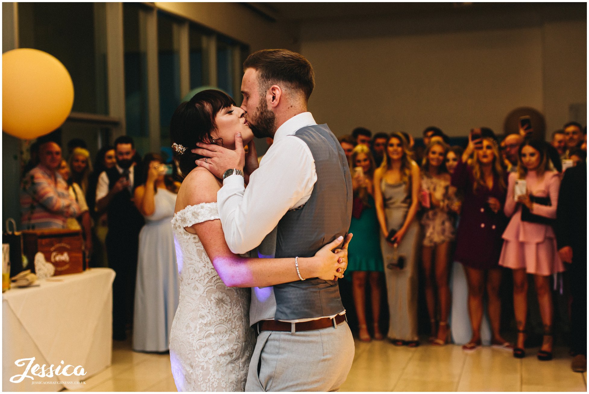 husband and wife kiss during their first dance as a married couple