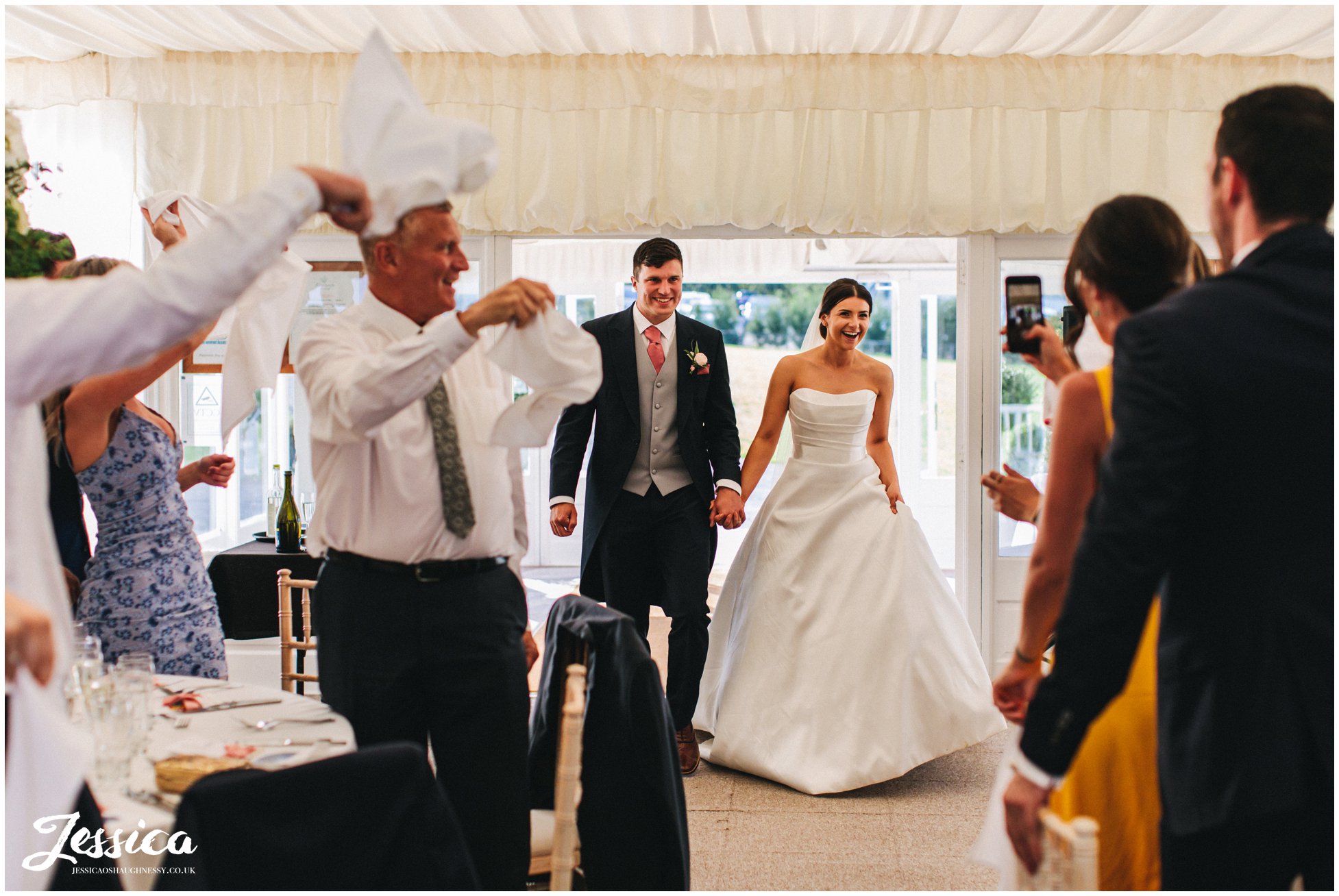 bride &amp; groom enter room for the wedding breakfast