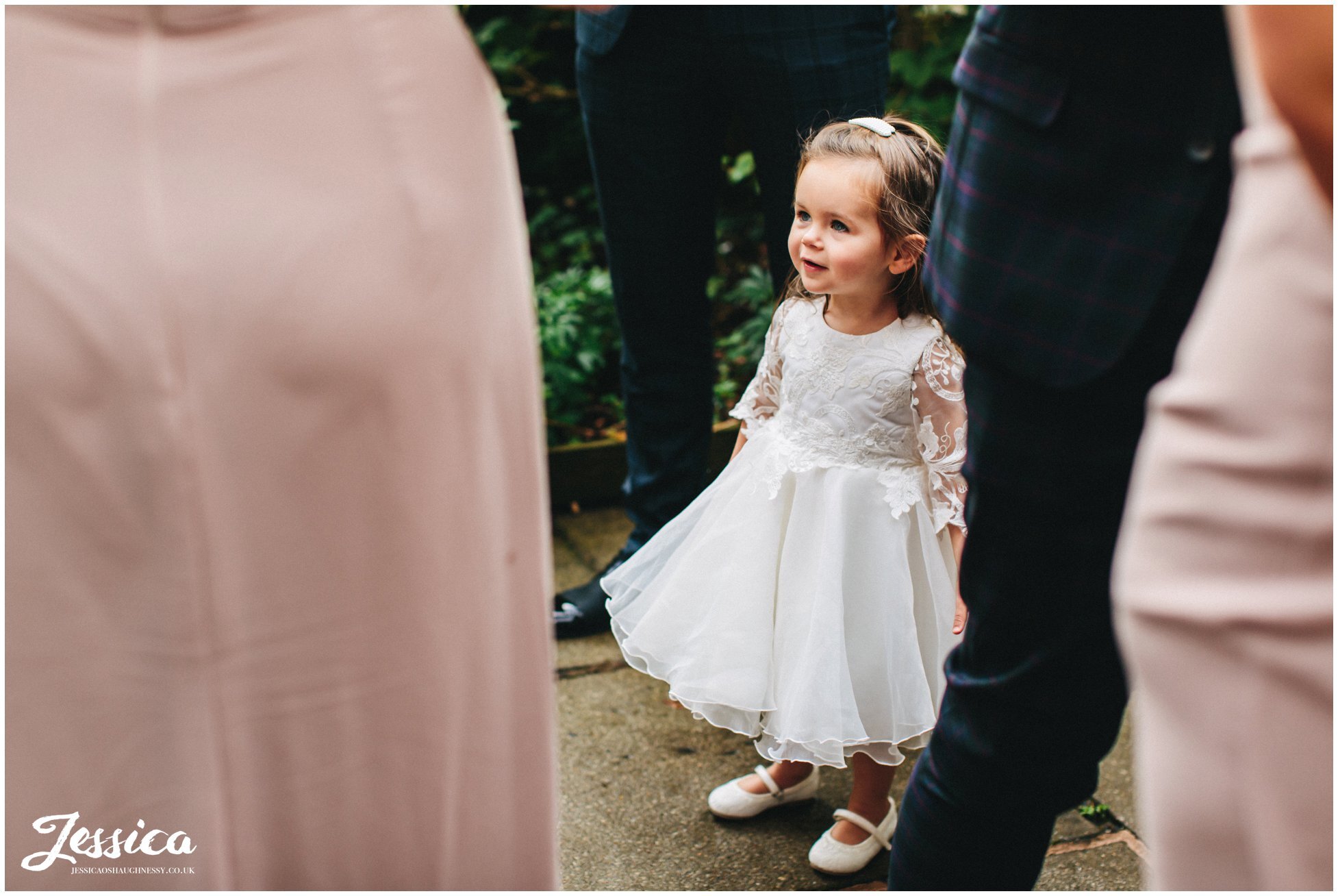 flower girl stands by mum at the oak tree of peover in cheshire