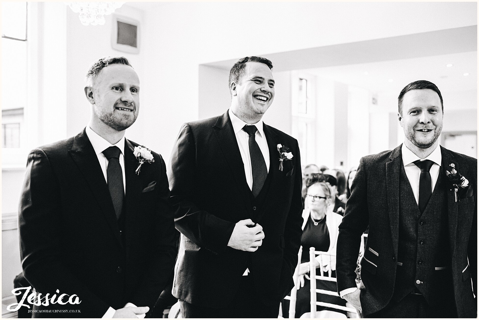groom &amp; groomsmen wait at the front of the aisle