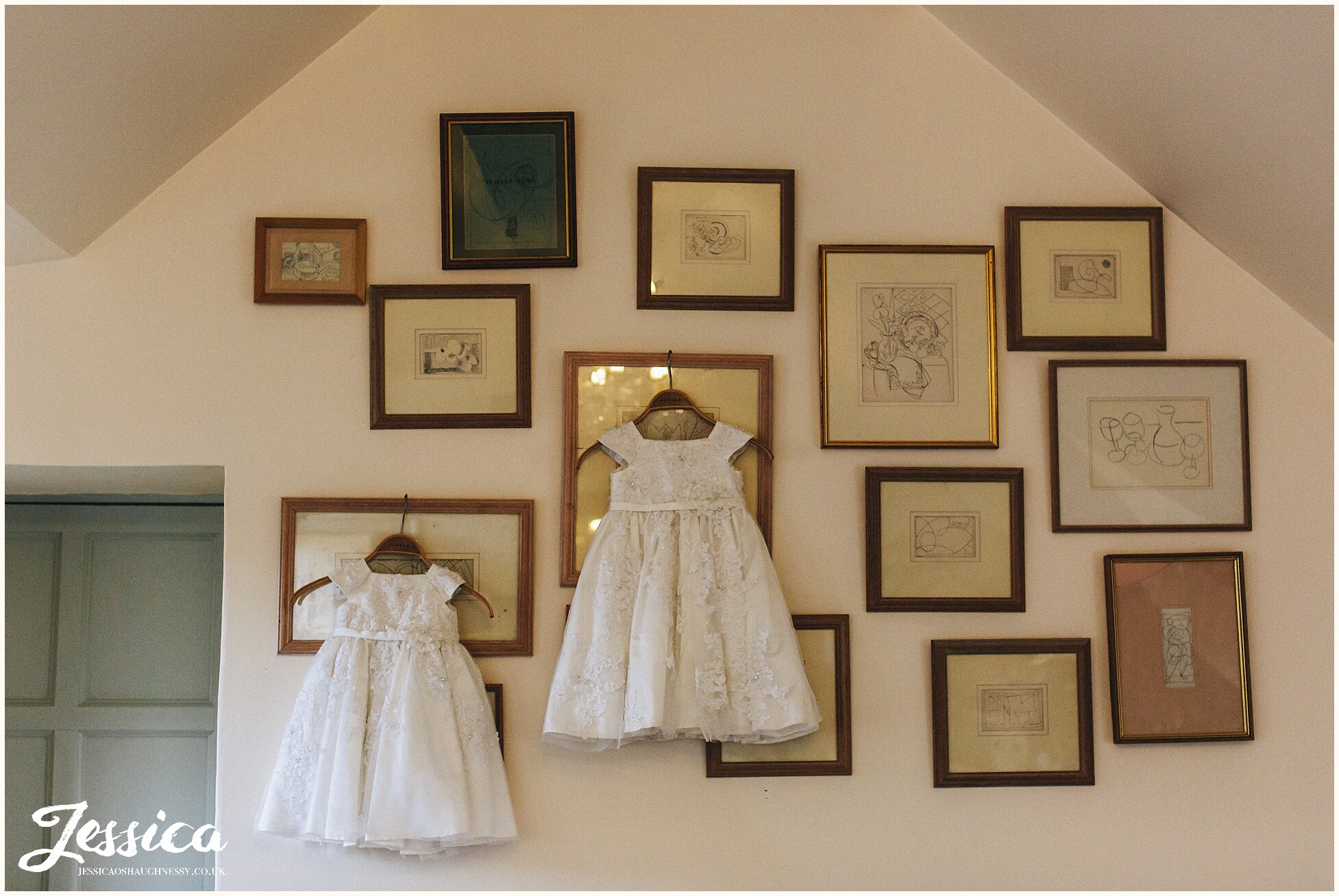 flower girl dresses hang from photo wall