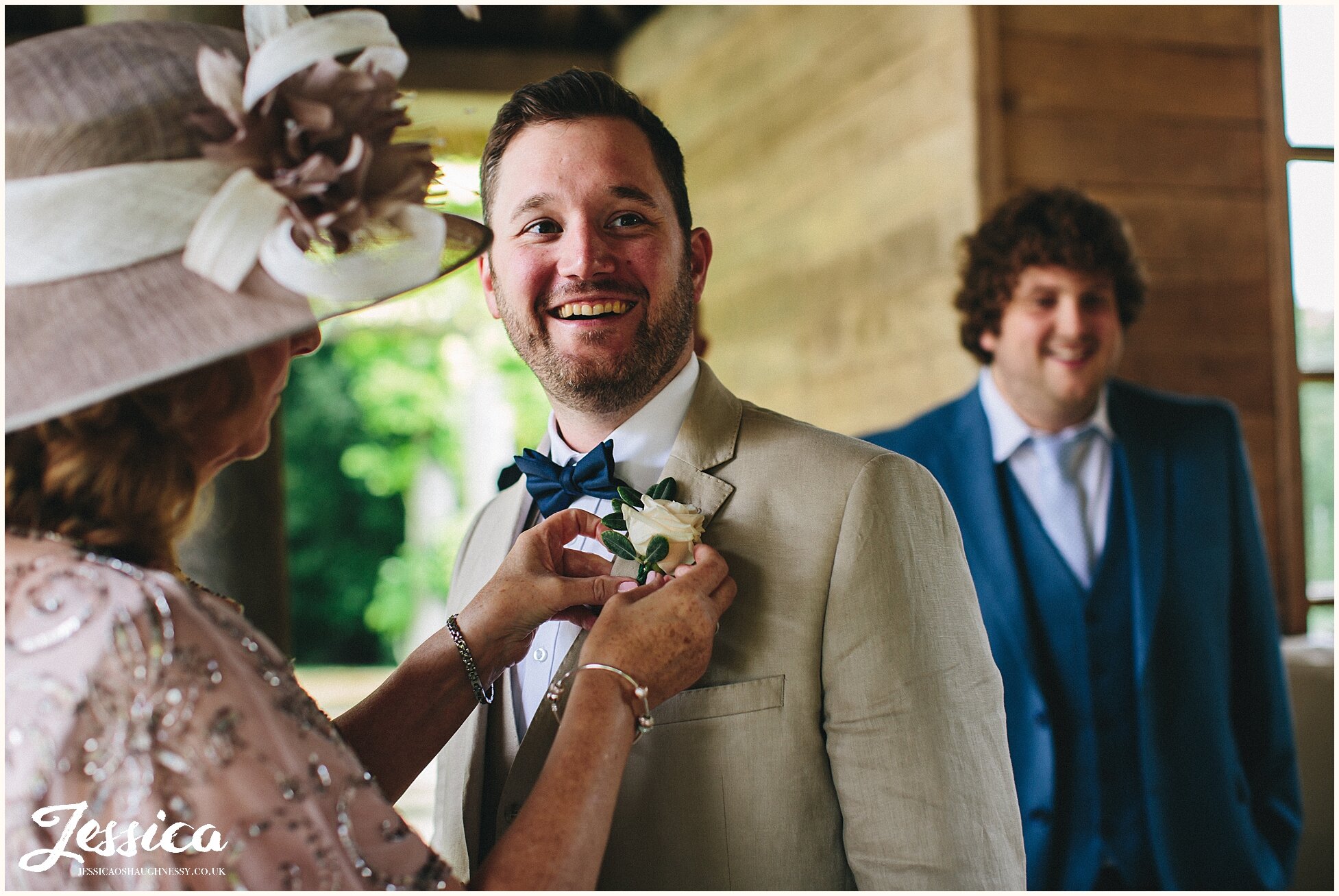 mother of the groom puts on his buttonhole