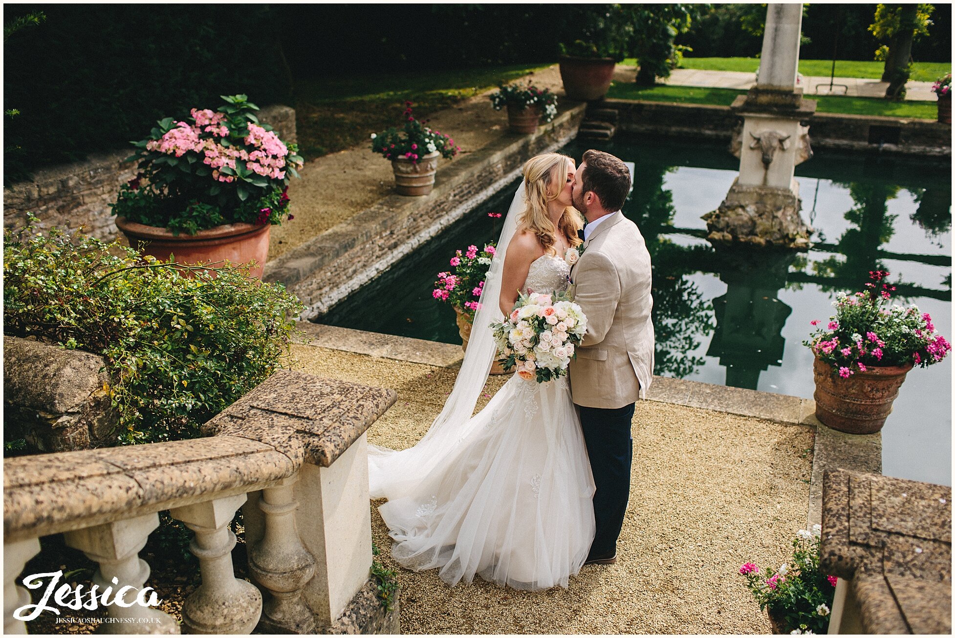 newly wed's kissing by the lost orangery lake