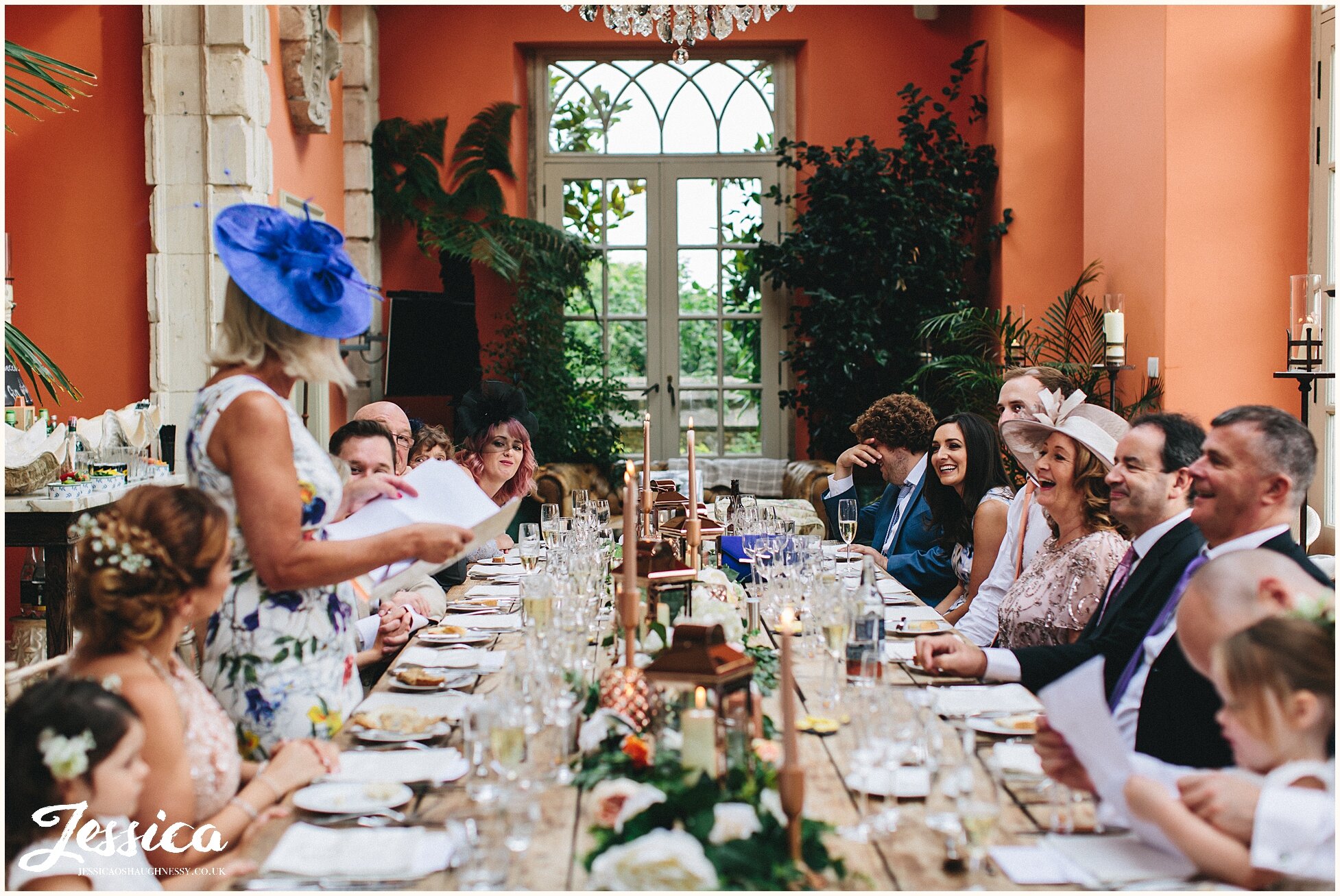 mother of the bride stands to deliver speech before meal - the lost orangery wedding photography